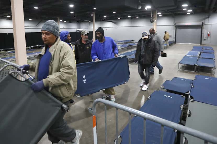 Volunteers prepare cots for those who will use the Temporary Inclement Weather Shelter at...