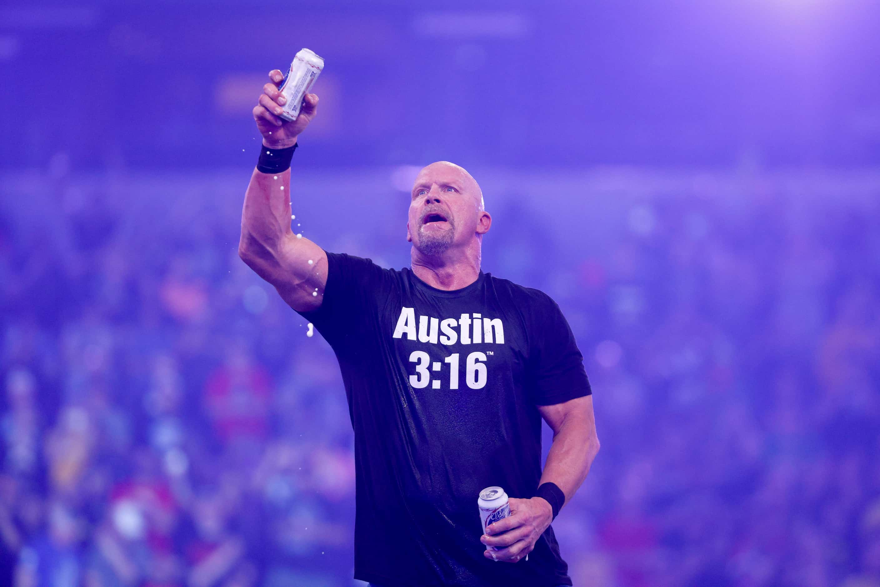 “Stone Cold” Steve Austin raises a beer after defeating Kevin Owens in a match at...