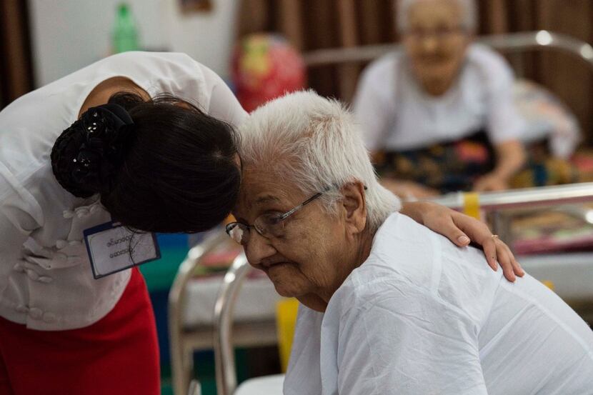 An elderly resident of the "Twilight Villa" nursing home gets attention from one of the...