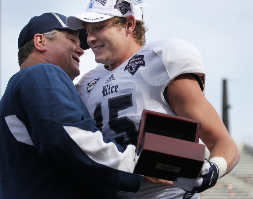 Rice University's #15 Jordan Taylor gets a hug from his head coach David Bailiff as he gets...