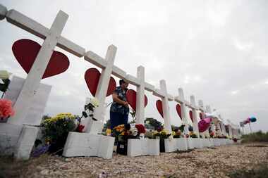A woman visits a makeshift memorial along the highway for the victims of the church shooting...