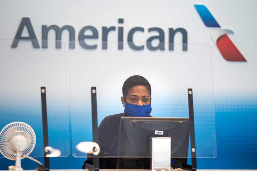 An American Airlines employee waits to help the next passenger check luggage in Terminal A...