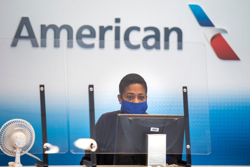 An American Airlines employee waits to help a passenger check luggage in at Terminal A at...