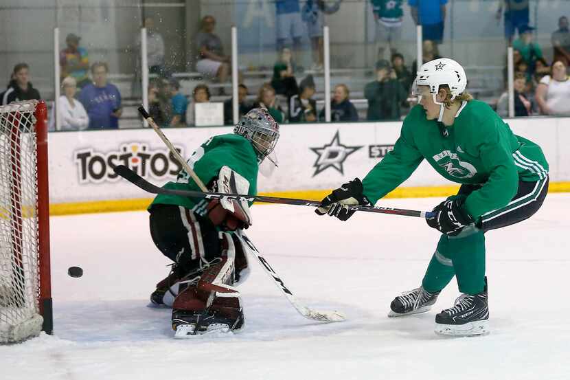 FILE - Stars forward Albin Eriksson (right) shoots the puck on goalie Anthony Popovich...