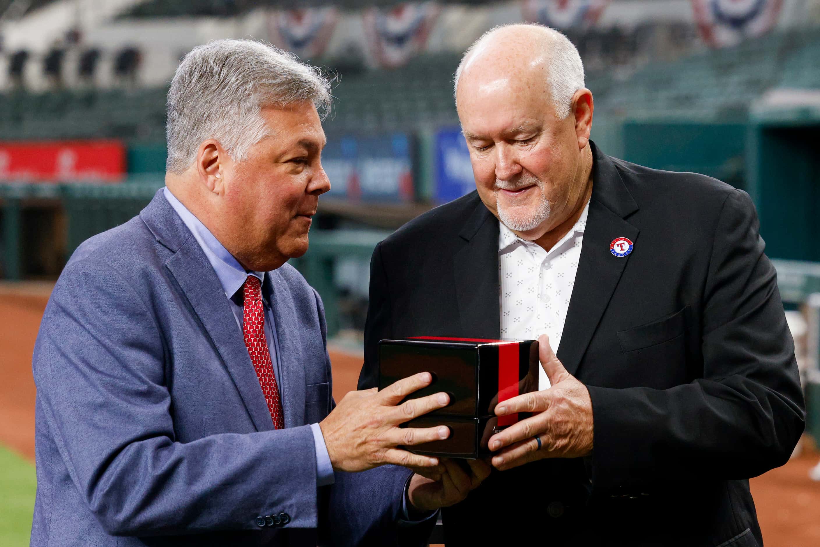 Neil Leibman, Texas Rangers president of business operations, presents Chuck Morgan, Texas...