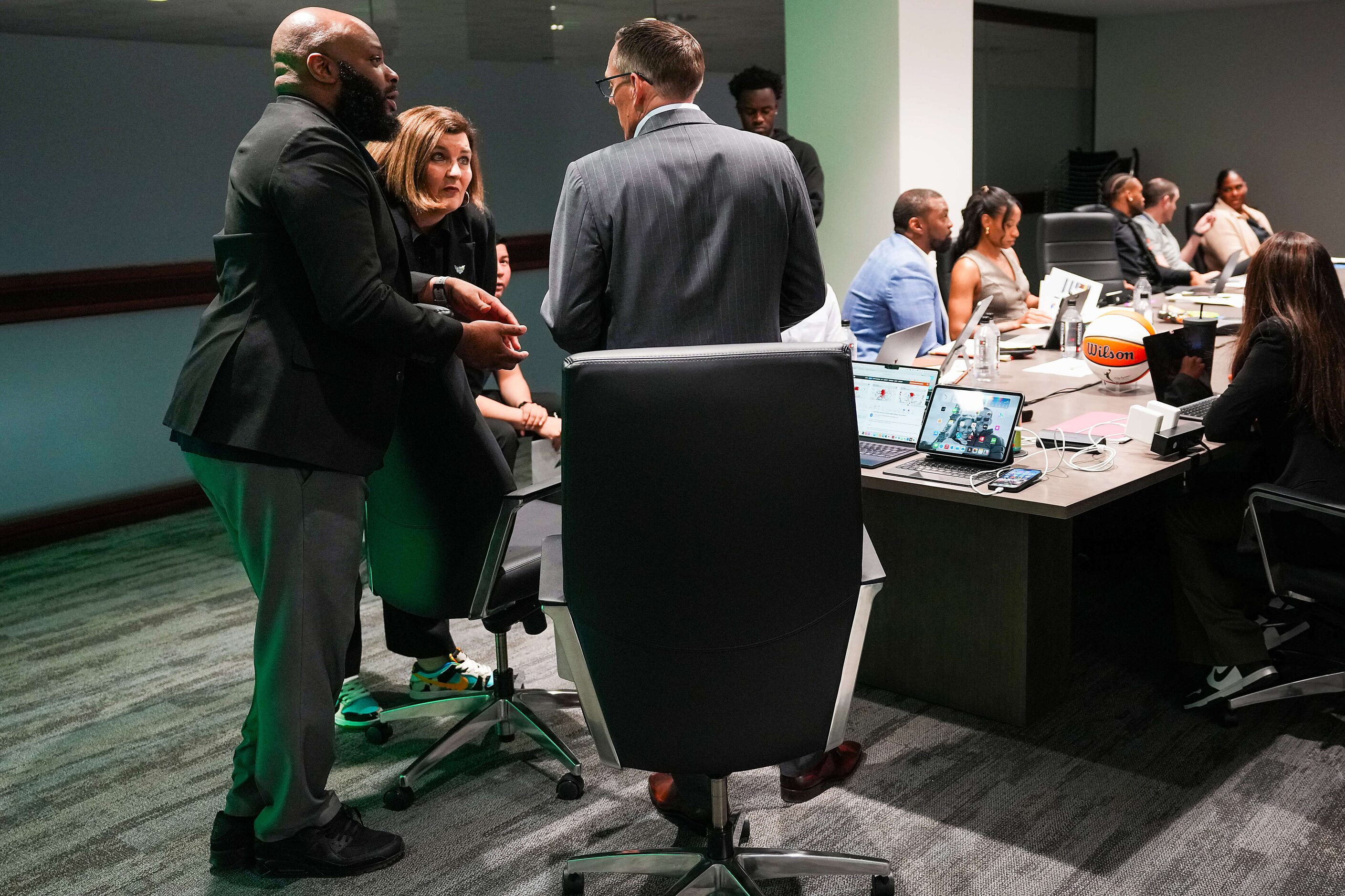 Dallas Wings President and CEO Greg Bibb (back to camera) confers with assistant general...