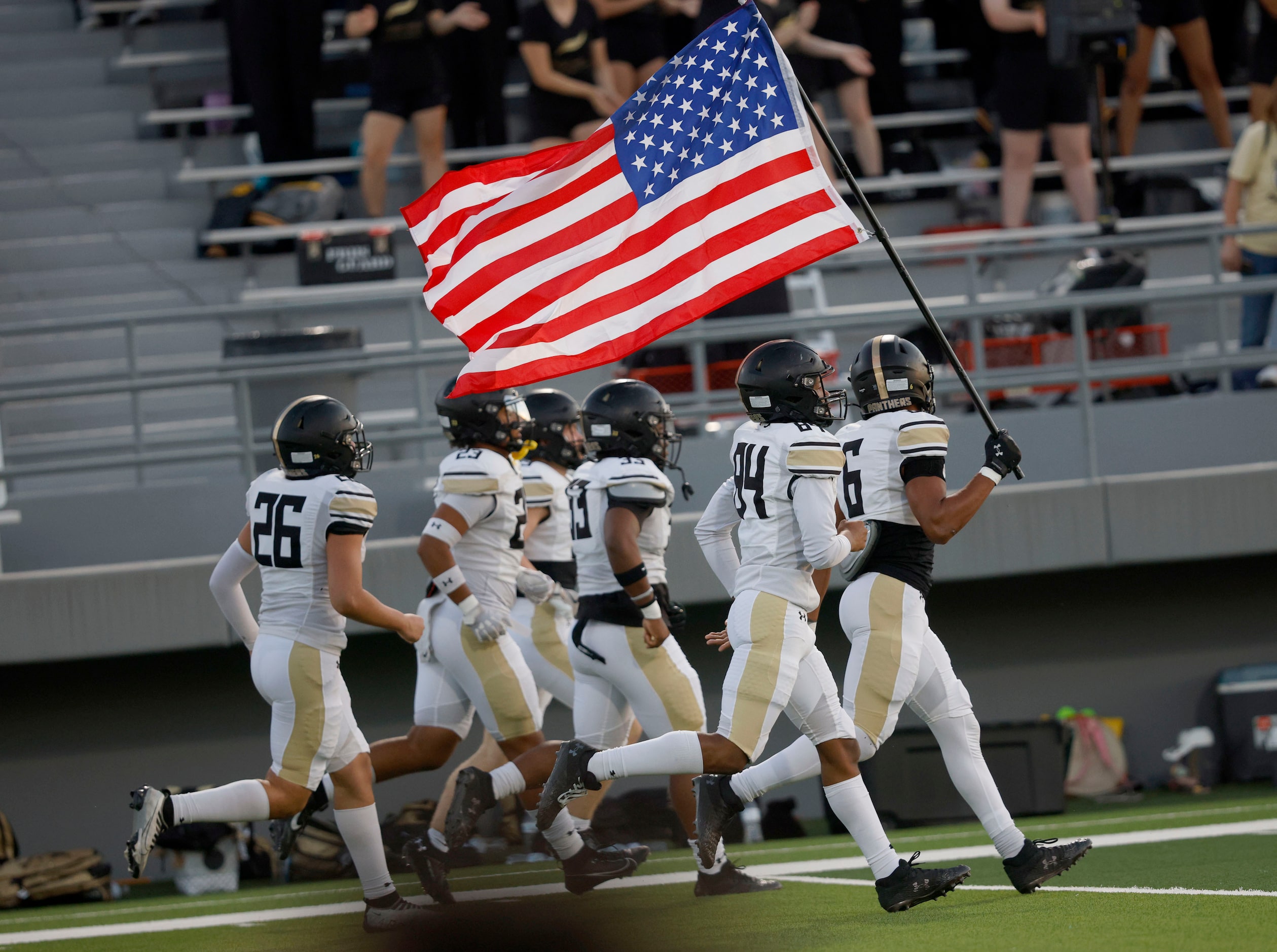 Fossil Ridge players run onto the field before a high school football game against Richland...