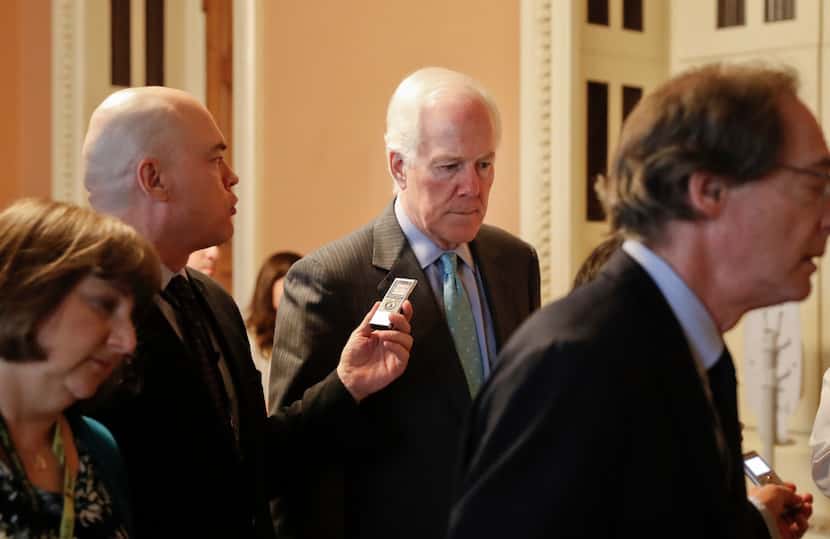Senate Majority Whip John Cornyn of Texas was pursued by members of the media as he walked...