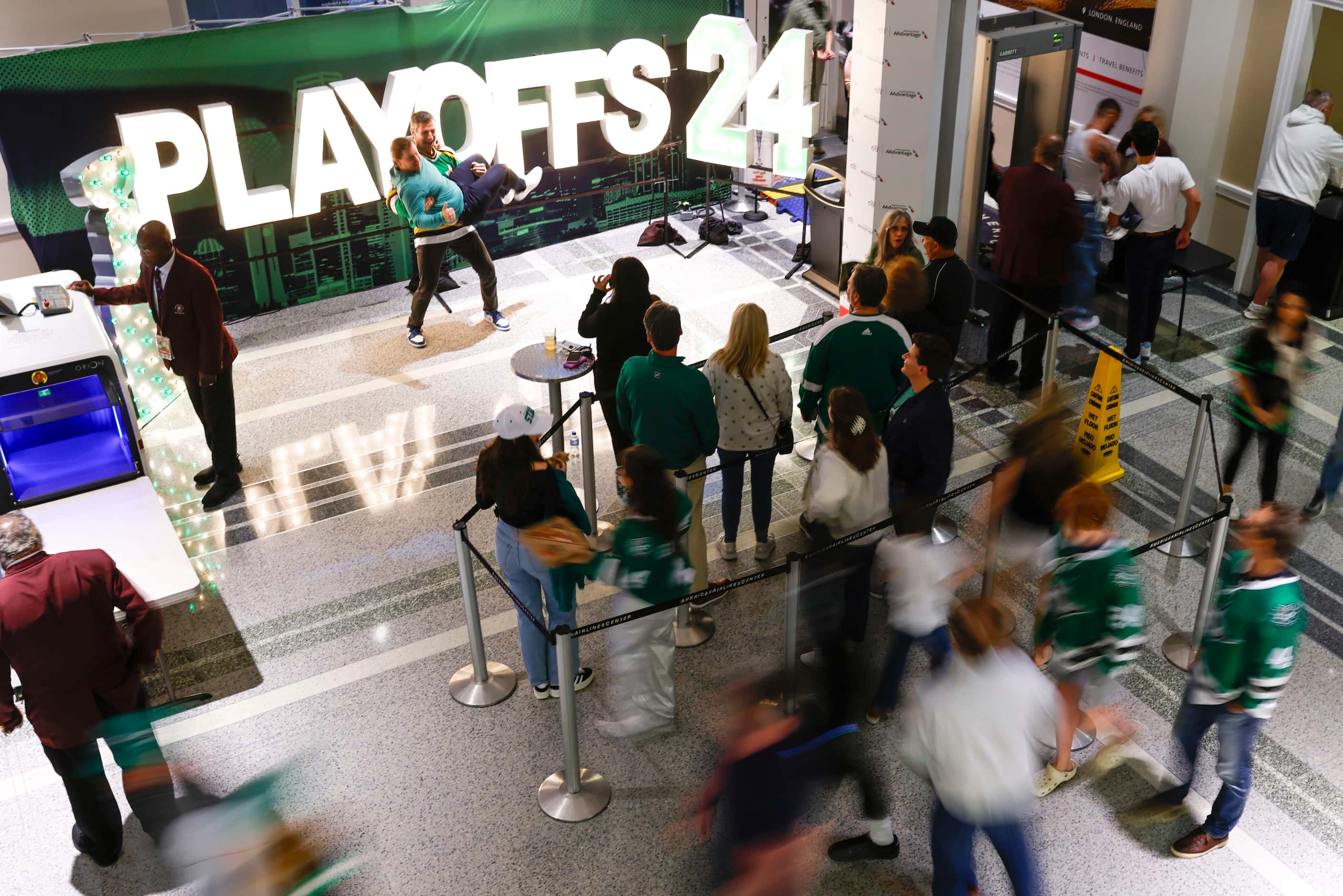 Fans pose for photos in front of a sign as others cruises through the concourse ahead of...
