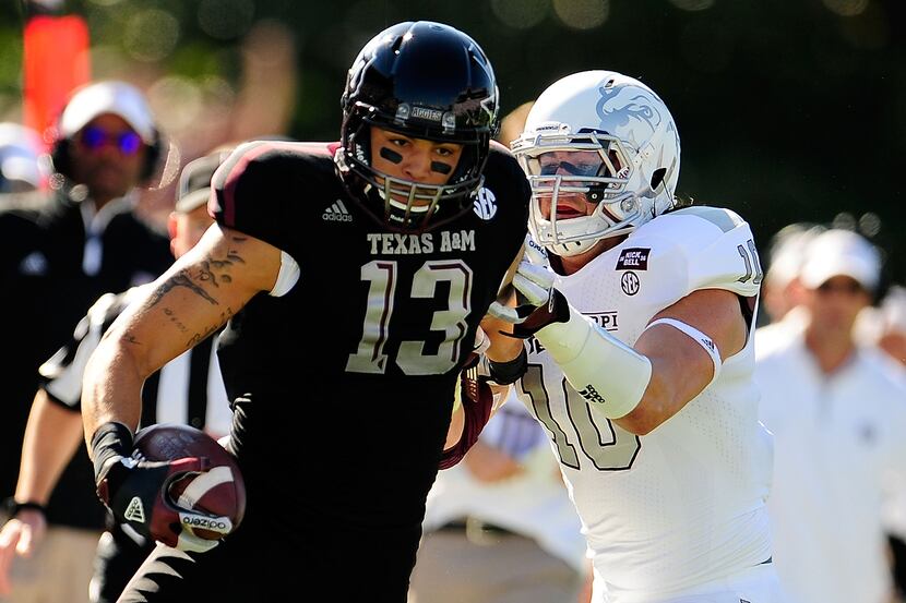 STARKVILLE, MS - NOVEMBER 03:  Mike Evans #13 of the Texas A&M Aggies avoids a tackle by...