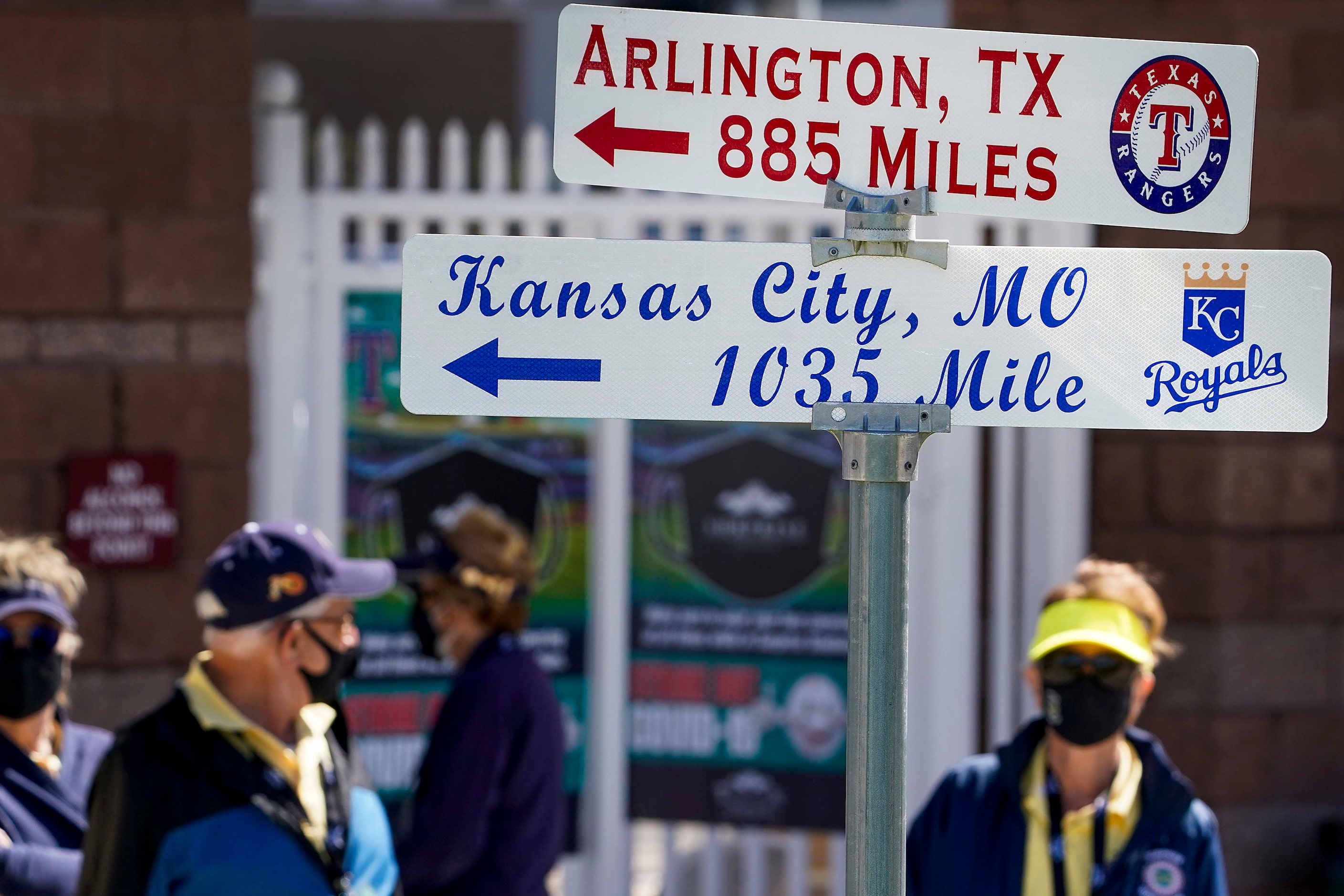 Ushers wear face coverings as the gates open for fans before a spring training game between...