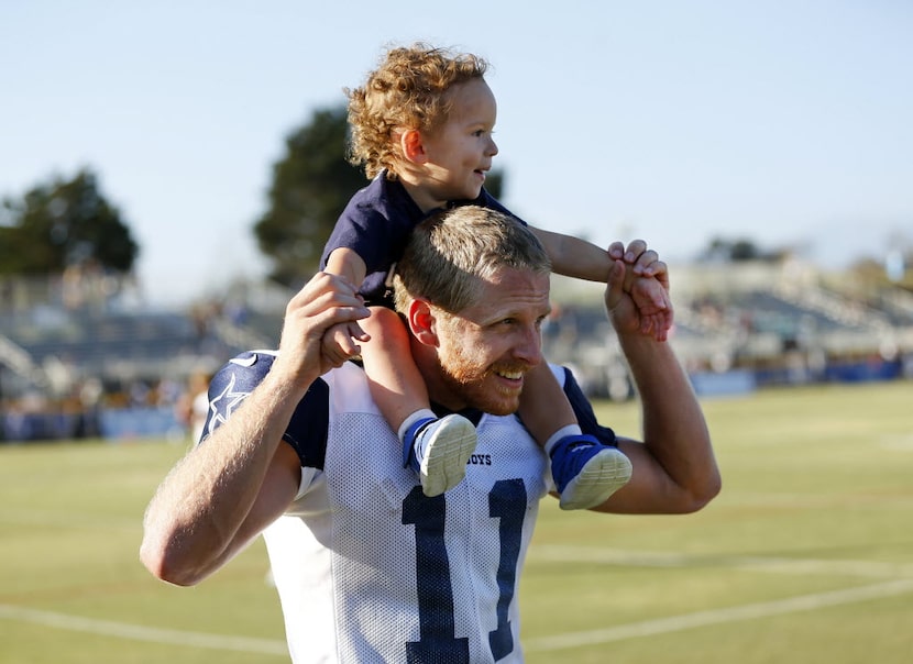 Dallas Cowboys wide receiver Cole Beasley (11) gives his son Ace a ride on his shoulders...