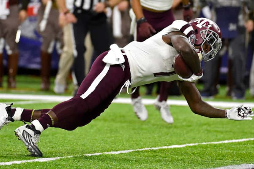 Texas A&M running back Keith Ford, right, falls into the end zone for a touchdown past...