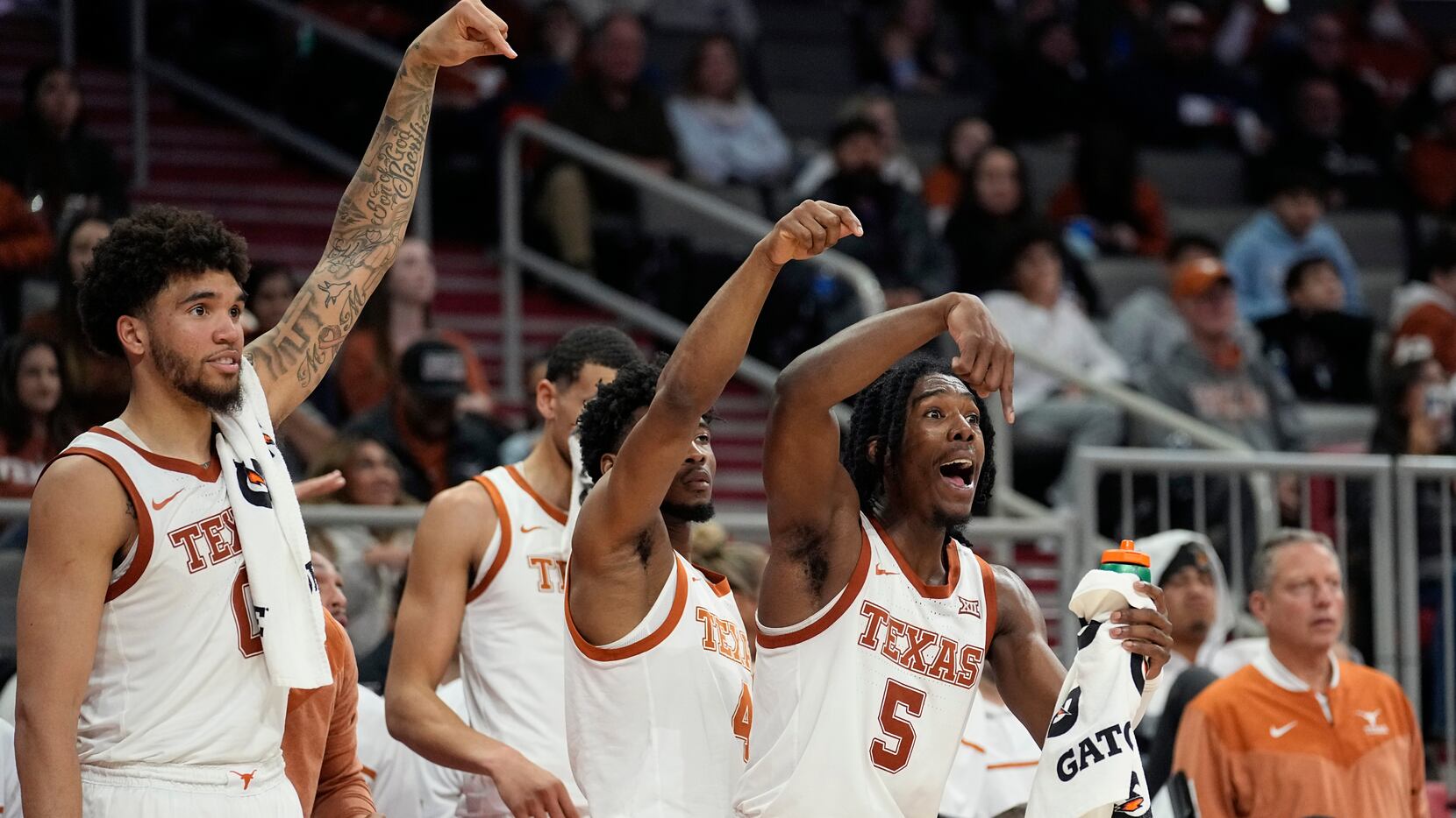Texas forward Timmy Allen (0), guard Tyrese Hunter (4) and guard Marcus Carr (5) reacts to a...