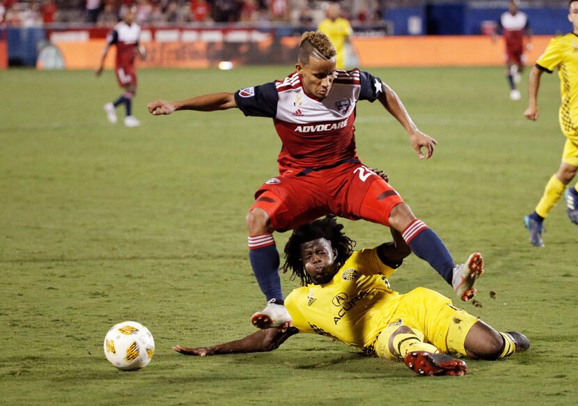 Columbus Crew defender Lalas Abubakar, bottom, slide tackles the ball away from FC Dallas...