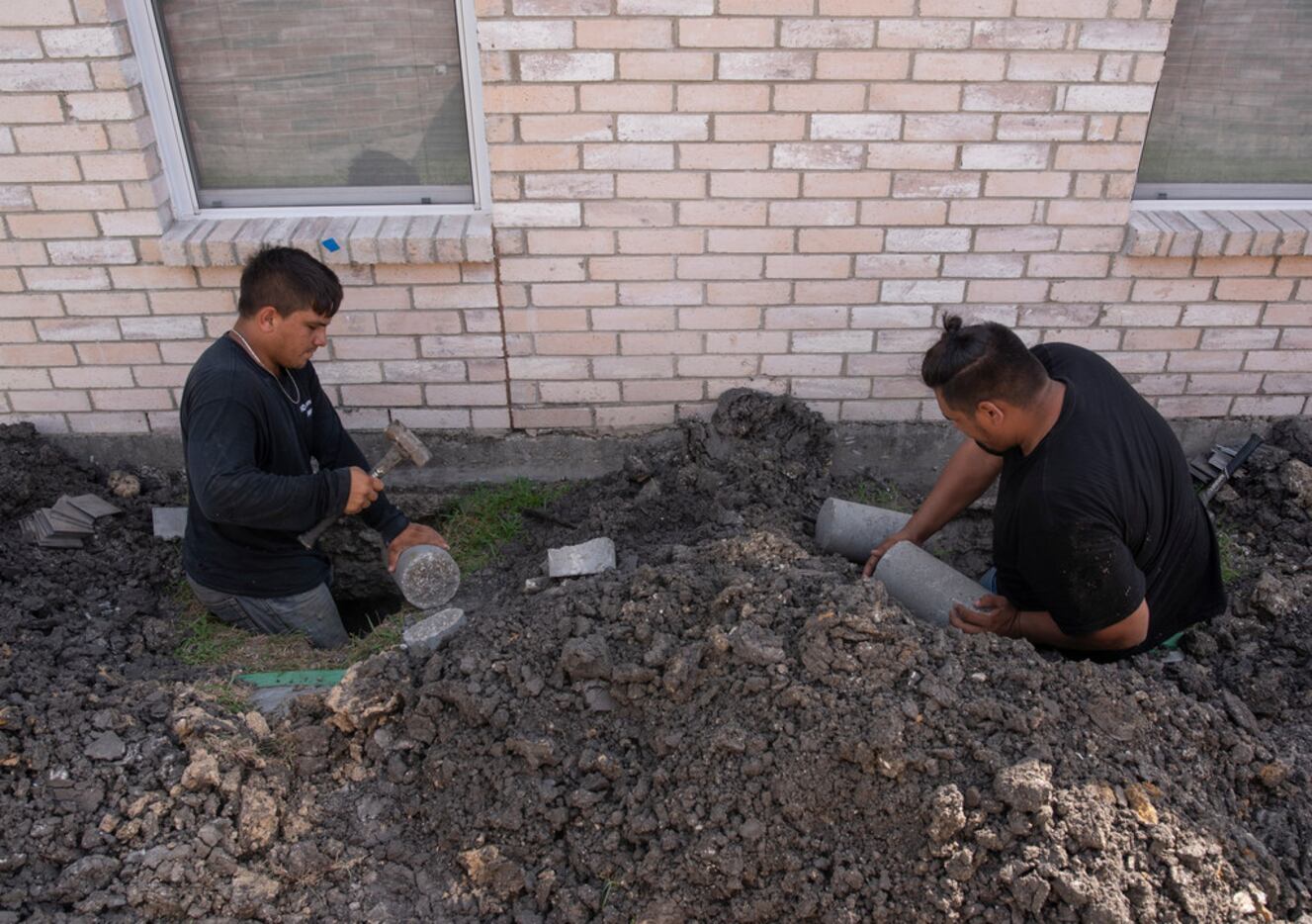 Nelson Rodriguez (left) and Asnider Rodriguez, employees with HD Foundations, put concrete...