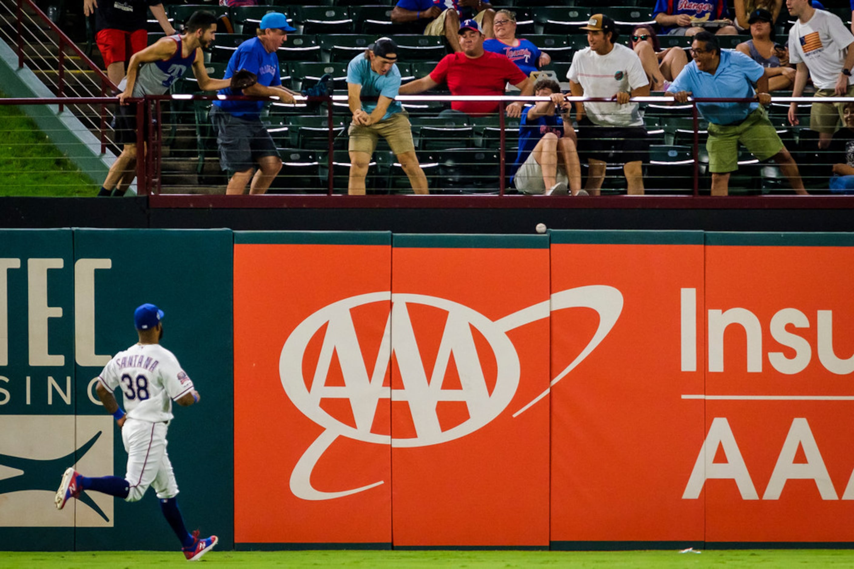 Texas Rangers infielder Danny Santana (38) watches fans try to catch a 3-run home run off...