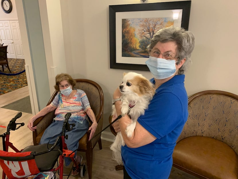 Ellen Feik (right) holds Faith, the Peekapoo owned by Ridgmar Place resident Faye Dickinson...