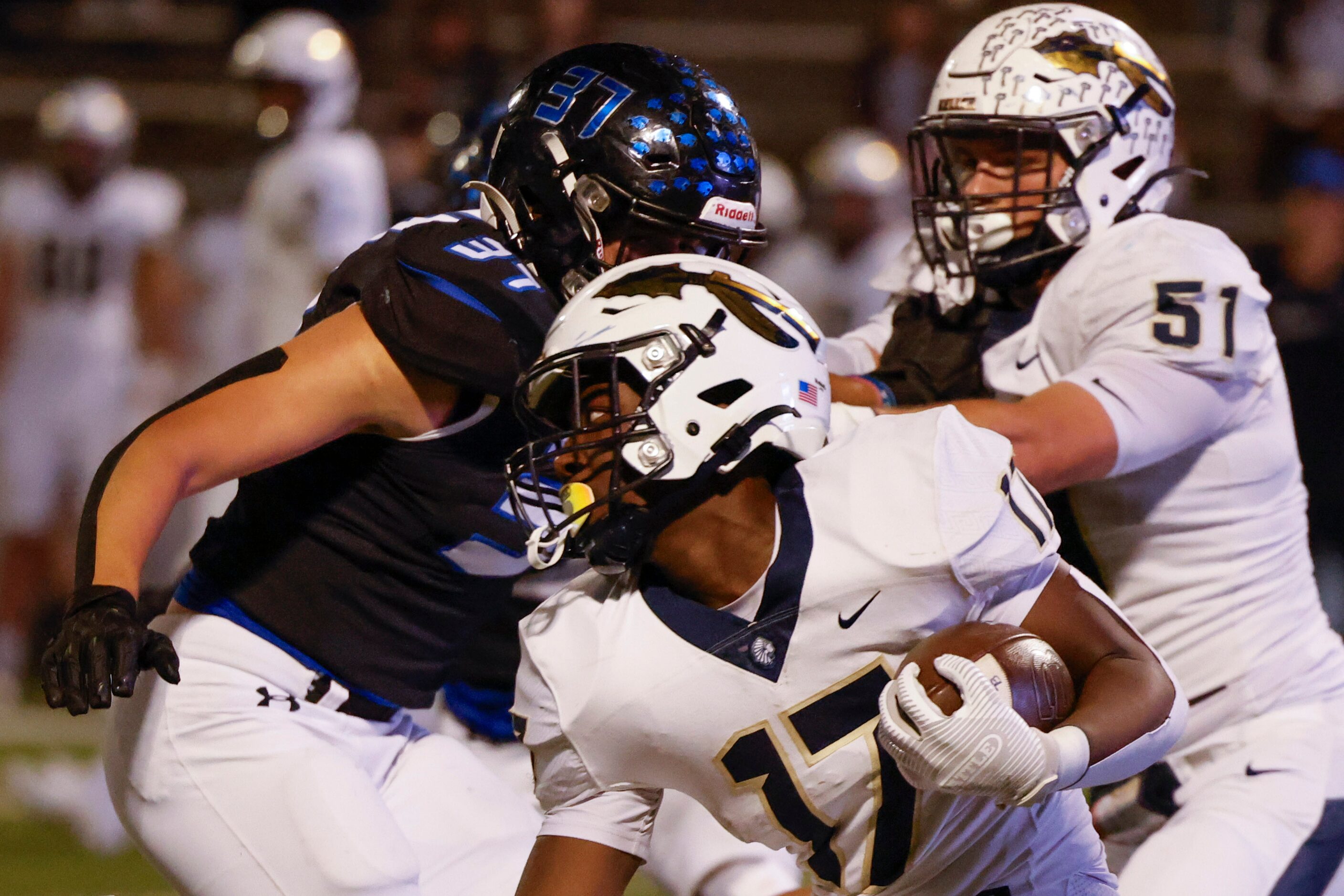 Keller High School’s Kaleb Malzac (17) tries to run past Byron Nelson’s Maddox Smith (37)...