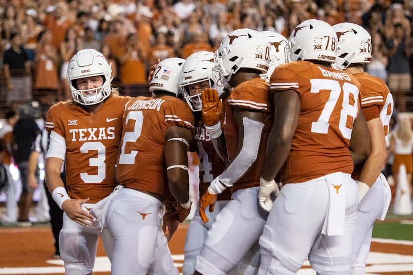 Texas running back Roschon Johnson (2) celebrates with teammates, including Quinn Ewers (2),...