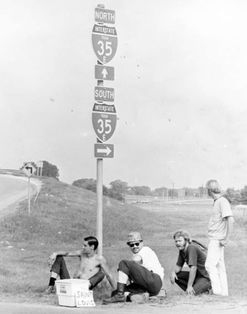 Texas International Pop Festival attendees next to an Interstate 35 road sign in Lewisville....