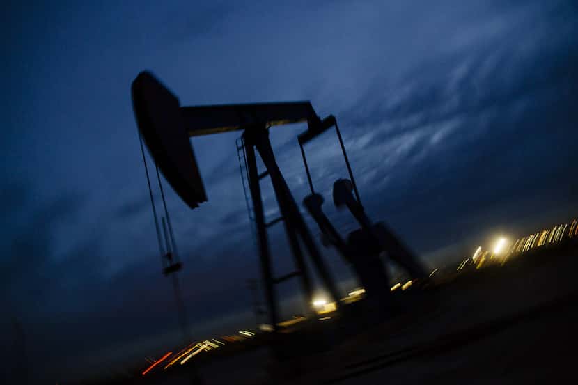 A pump jack stands at dusk on Dec. 16, 2018, in the Permian Basin area in Texas. (Angus...
