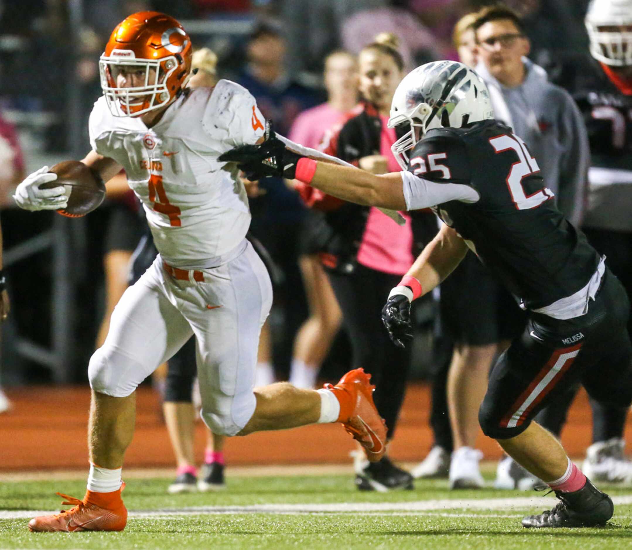 Celina running back Logan Point carries the ball past Melissa linebacker Caden Hayes (25)...