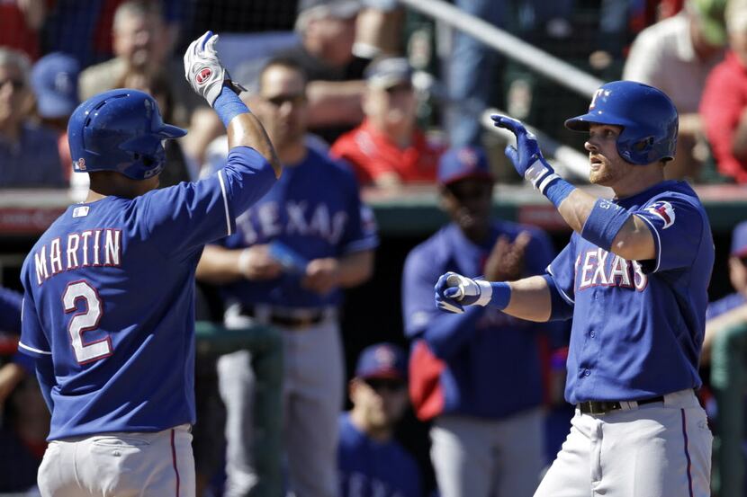 Texas Rangers' Craig Gentry, right, is greeted by Leonys Martin (2) after Gentry's two-run...