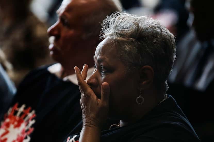 Marsha Jackson wipes a tear from her after as she listens to speakers during a press...