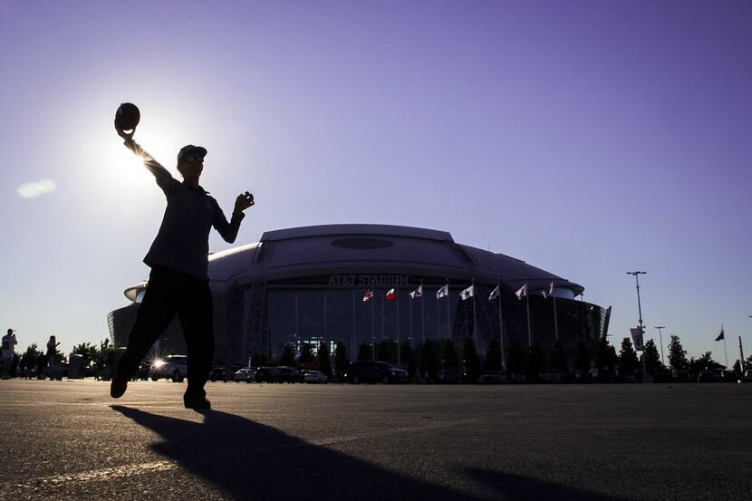 Cody Barclay of Corpus Christi, Texas, tosses a football outside the stadium as he tailgates...