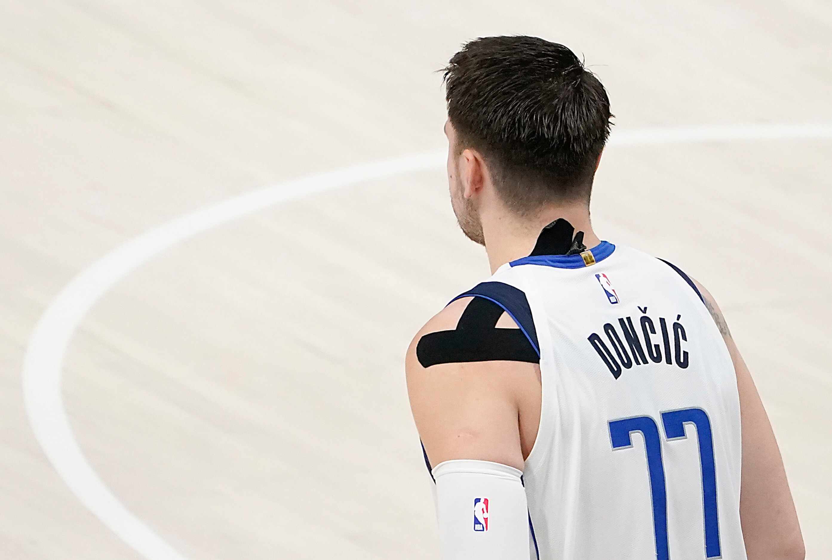 Dallas Mavericks guard Luka Doncic (77) wears tape on his shoulder and neck during the...