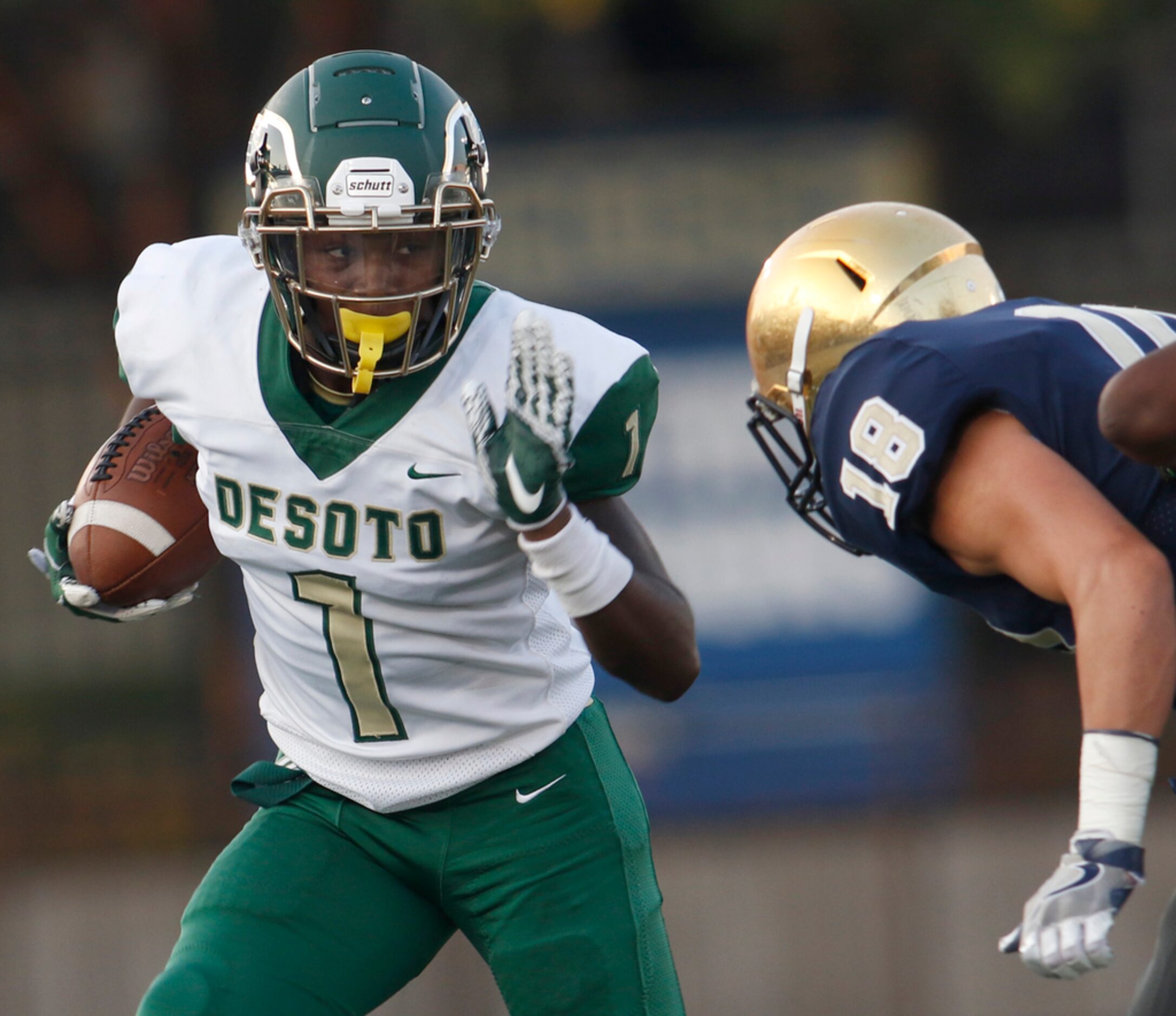 DeSoto receiver Jordan Brown (1) eyes the defensive pursuit of Jesuit defensive back Robert...