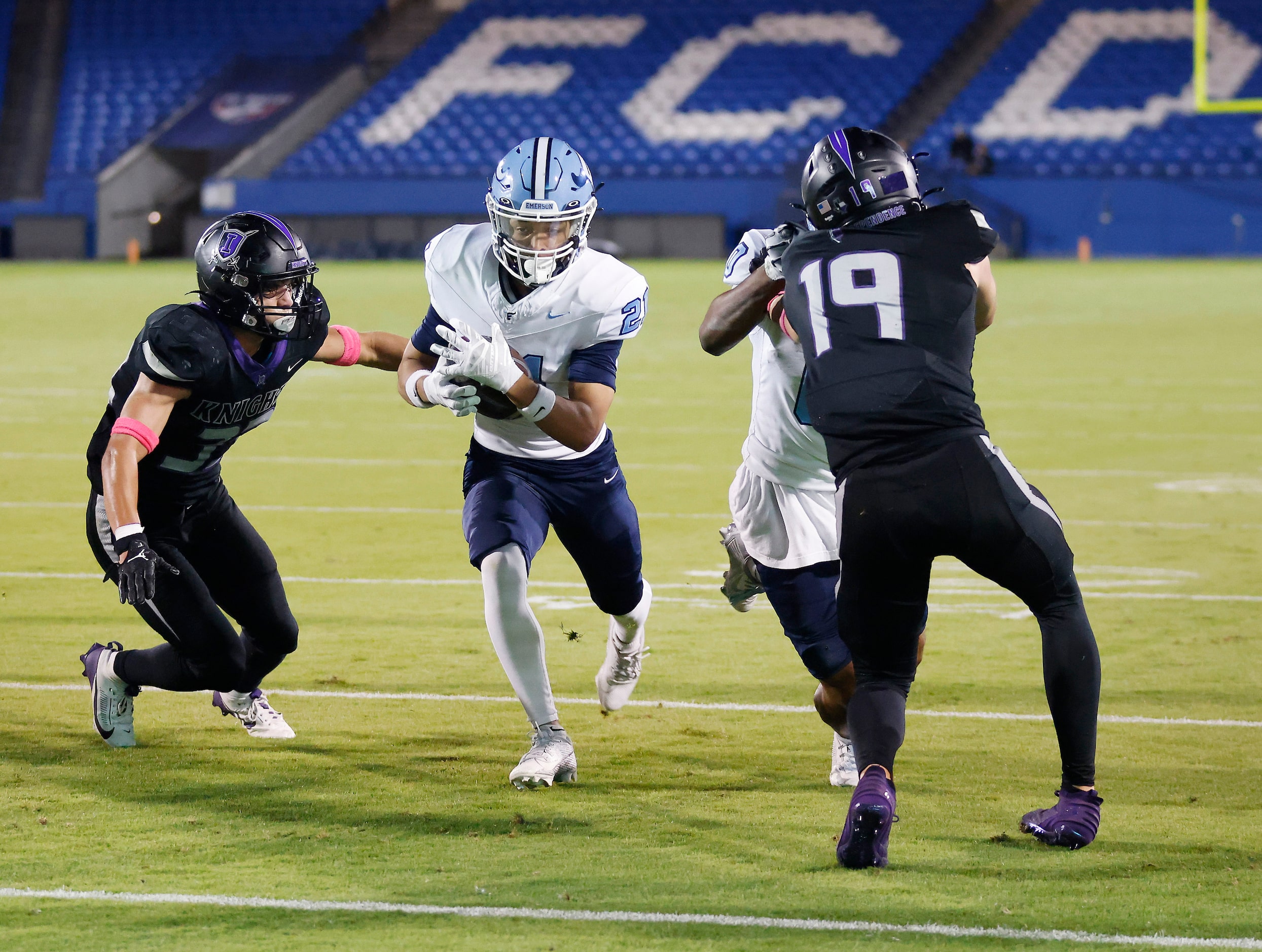 Frisco Emerson running back Persha Allen (21) squeezes through Frisco Independence defenders...