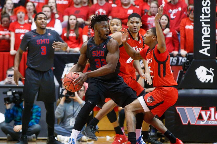 SMU's Semi Ojeleye (33) looks to pass against Cincinnati's Kevin Johnson, right, in the...