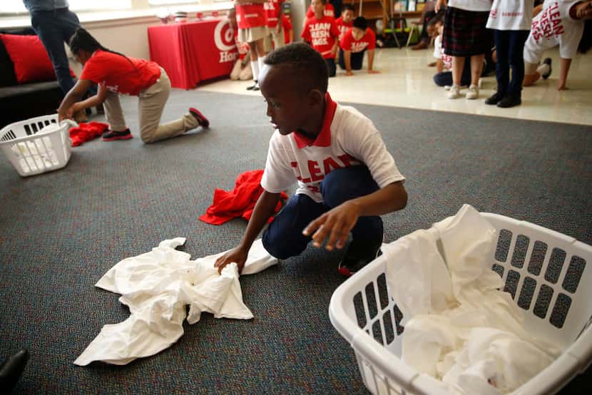 Jaylen Simpson, 8, gathers clothes during a laundry game at a celebration of Conn's HomePlus...