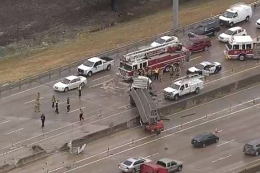 An 18-wheeler dangled over the edge of a barrier on Interstate 635 in Lake Highlands on...