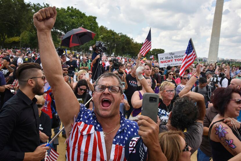 Rob Cortis of Livonia, Mich., joins the crowd in singing the national anthem at a pro-Trump...