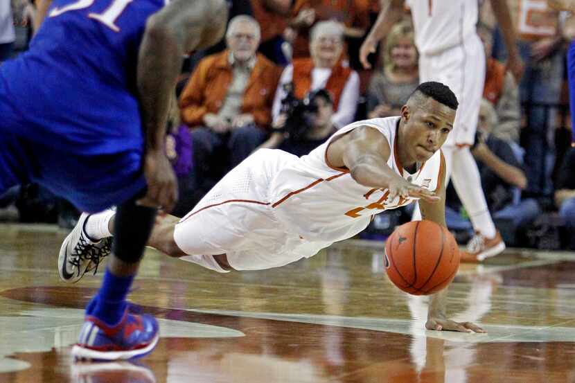 Texas guard Demarcus Holland (2) dives for a loose ball during the first half an NCAA...
