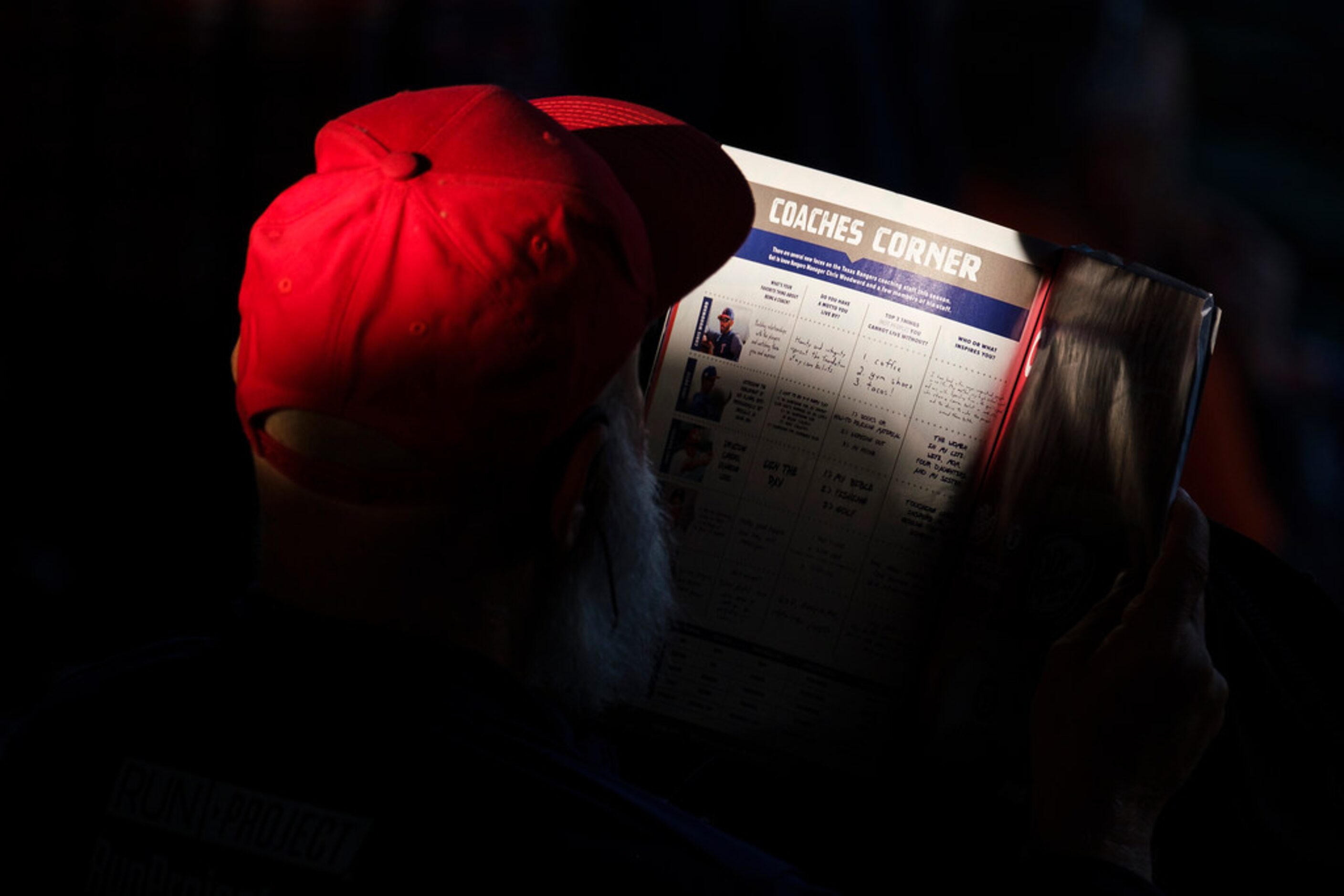 A fan reads the game program before the Texas Rangers game against the Houston Astros at...