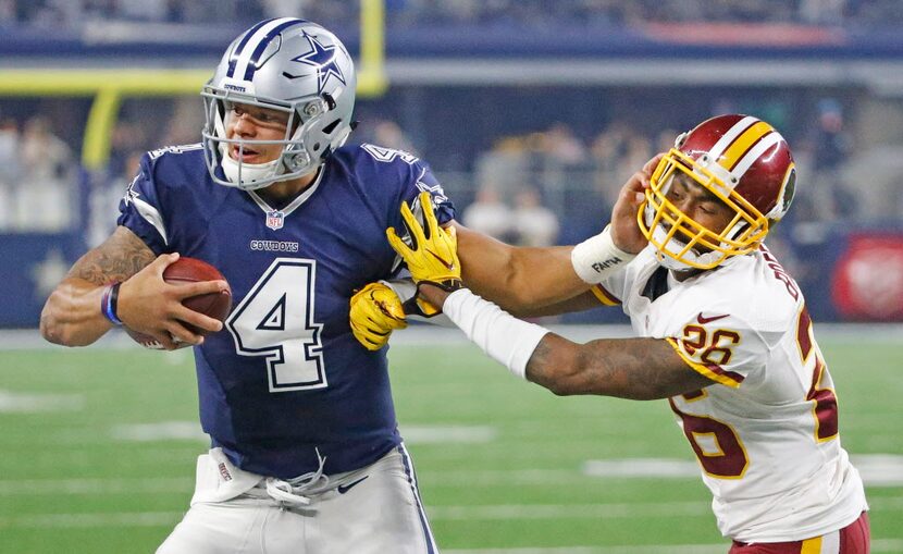 Cowboys quarterback Dak Prescott stiff-armed Redskins cornerback Bashaud Breeland during a...