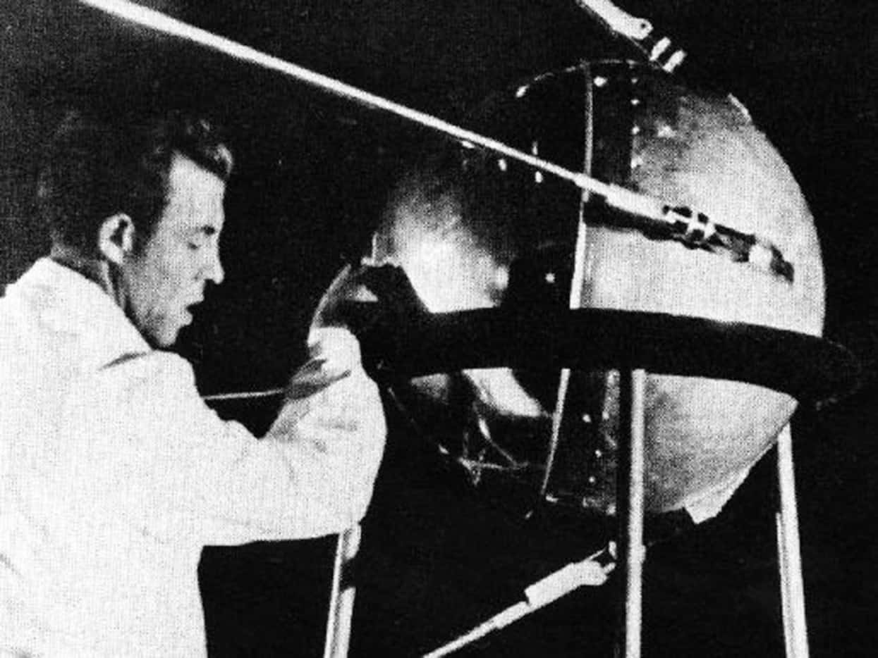 A technician puts the finishing touches on Sputnik 1, humanity's first artificial satellite. 