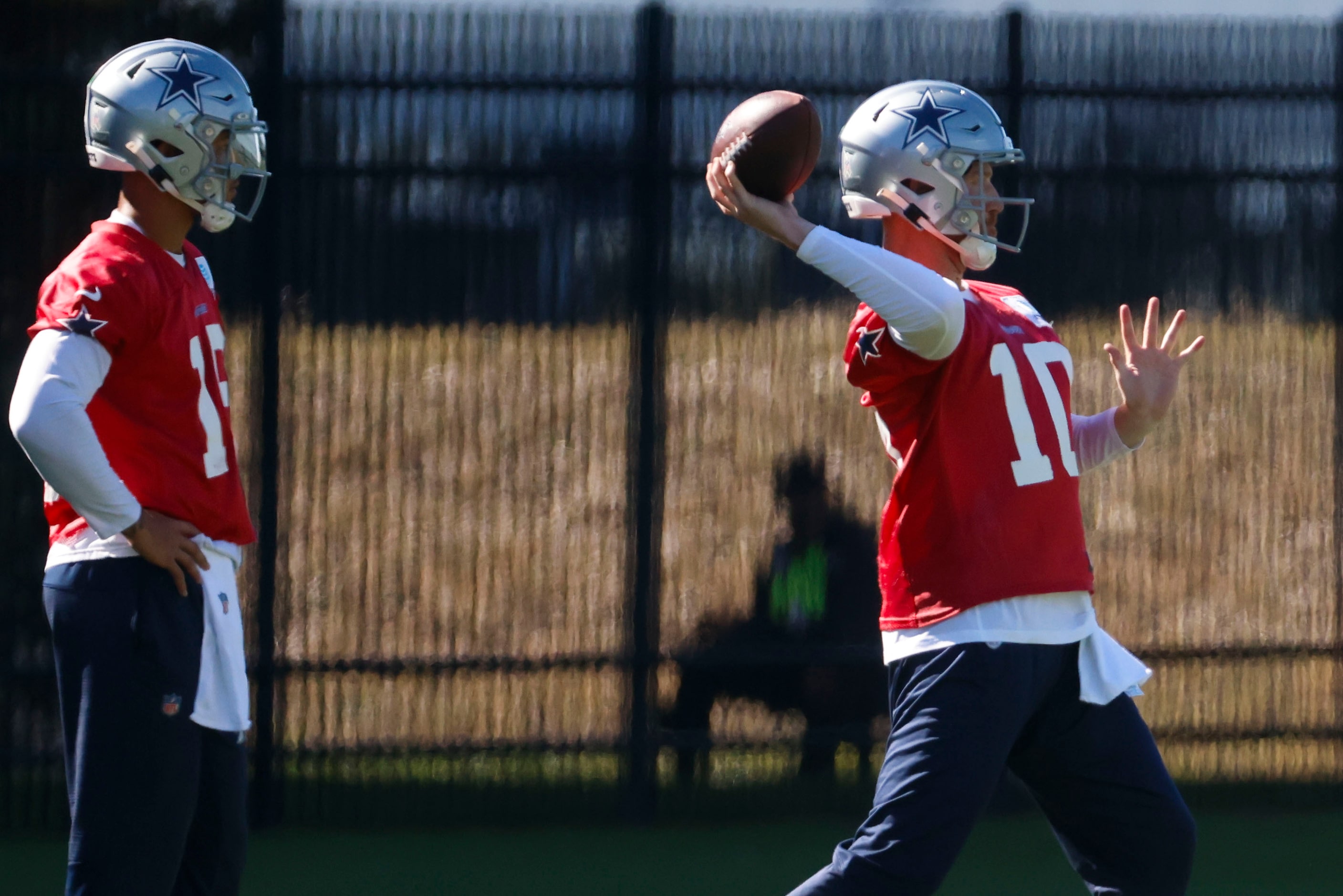 Dallas Cowboys quarterback Cooper Rush throws as  quarterback Trey Lance follows during a...