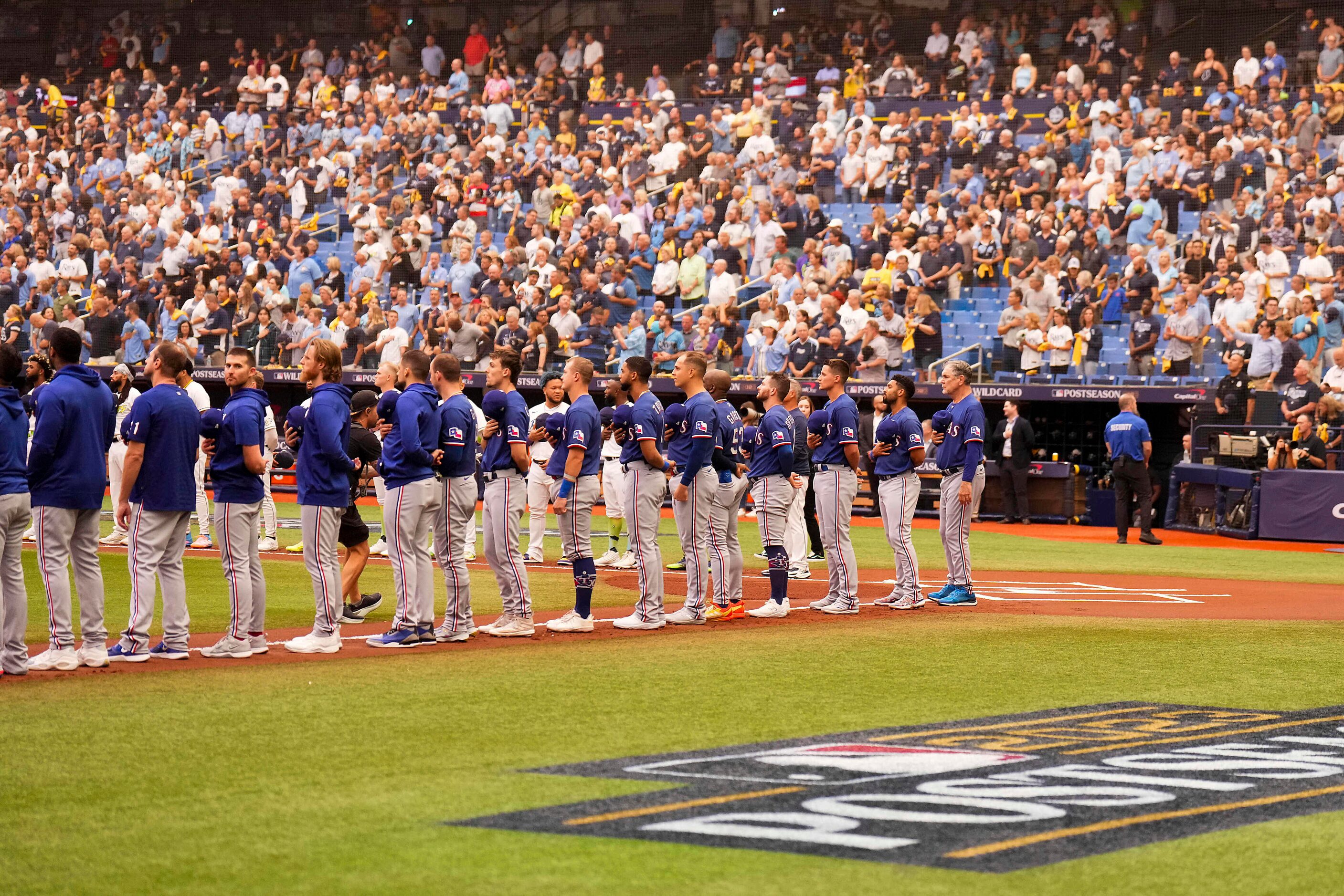 Texas Rangers players stand for the national anthem before an American League Wild Card...