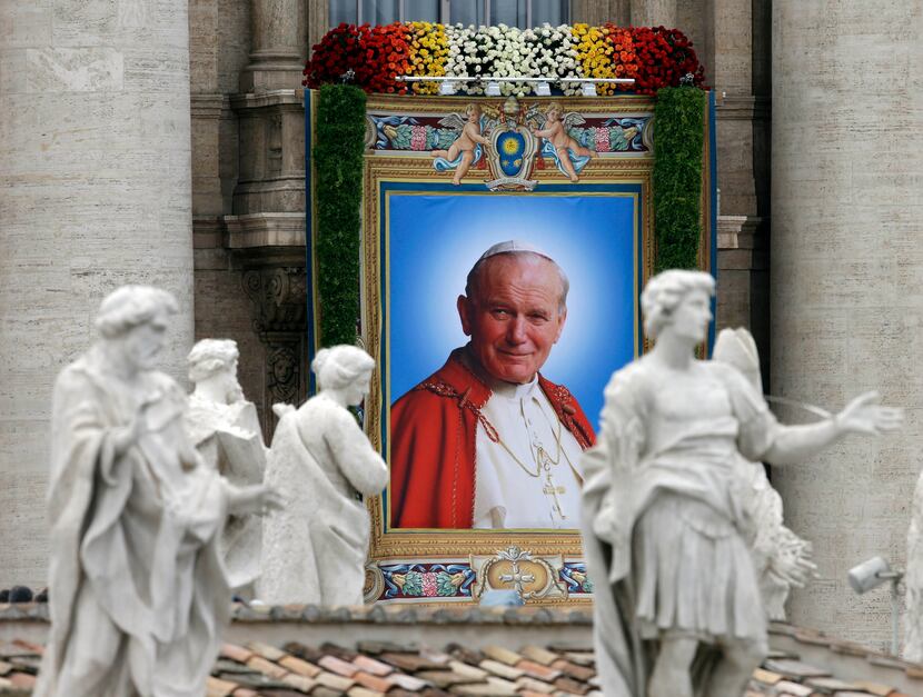 The tapestry showing Pope John Paul II hangs from the facade of St. Peter's Basilica during...