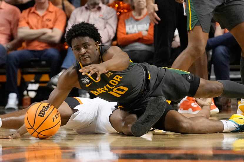 Baylor guard Adam Flagler (10) reaches over Oklahoma State guard Quion Williams, bottom, for...