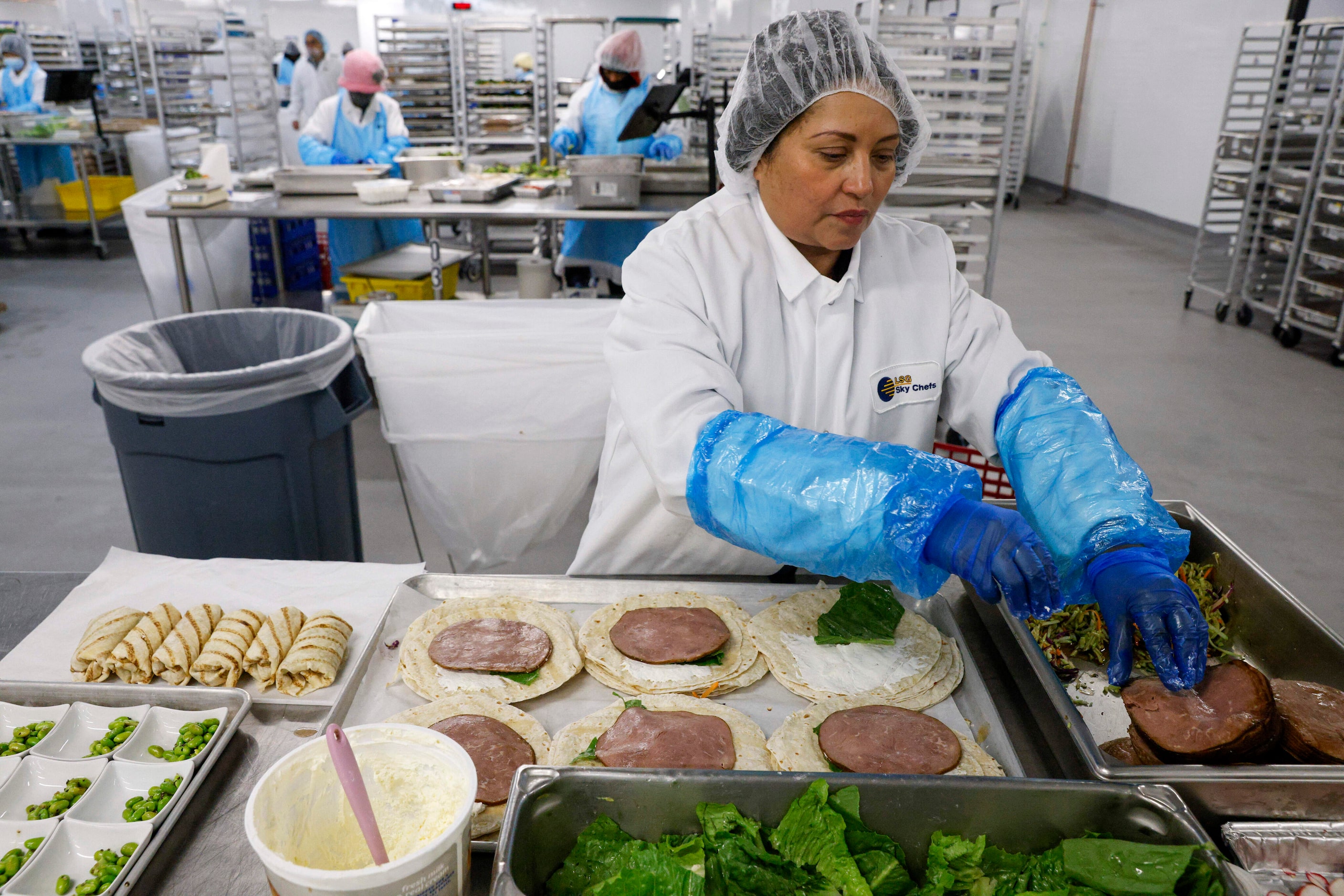 LSG Sky Chefs prep cook Noemi Funes prepares Asian BBQ wraps for an American Airlines flight...