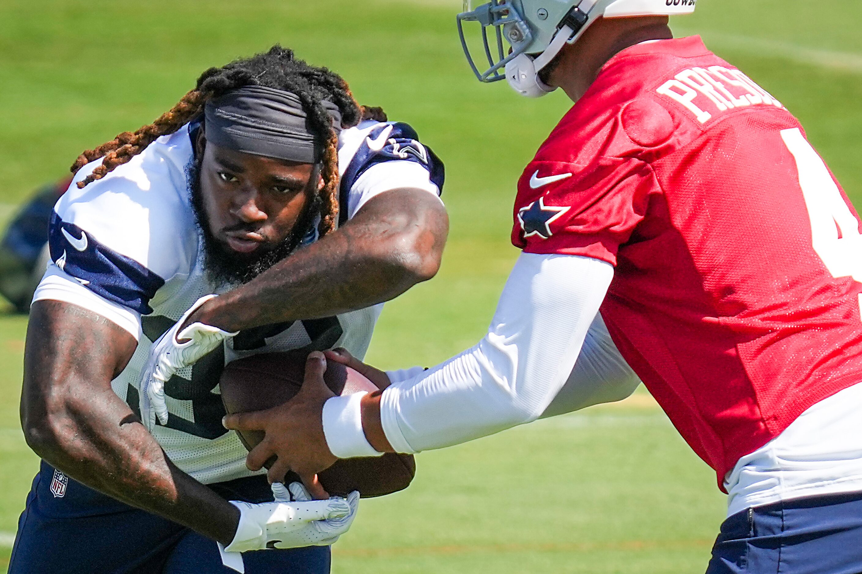 Dallas Cowboys running back Ronald Jones (32) works with quarterback Dak Prescott (4) during...