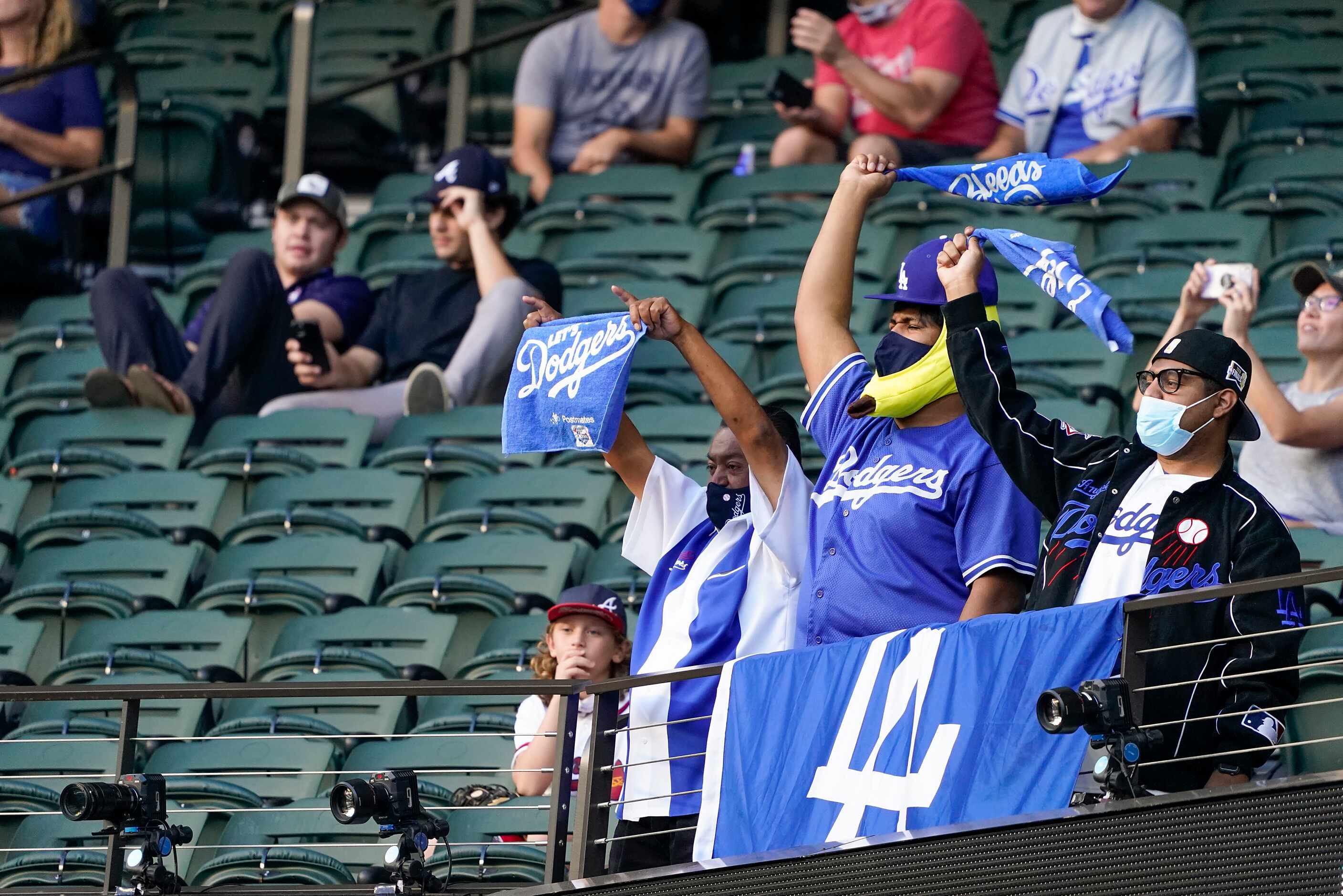 Los Angeles Dodgers fans cheer as their team takes the field to face the Atlanta Braves...