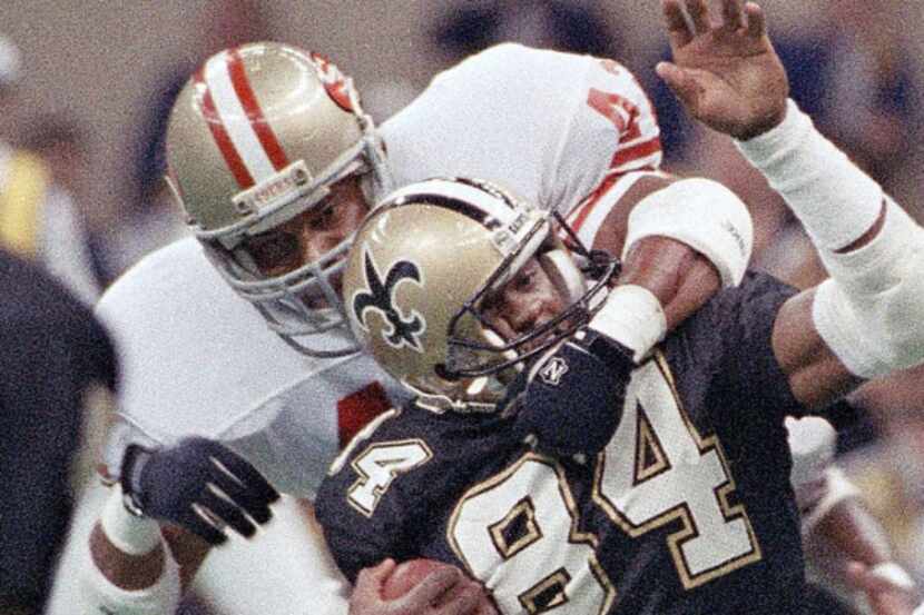 Saints receiver Eric Martin (84) was roughed up by the 49ers’ Ronnie Lott during a 1988...
