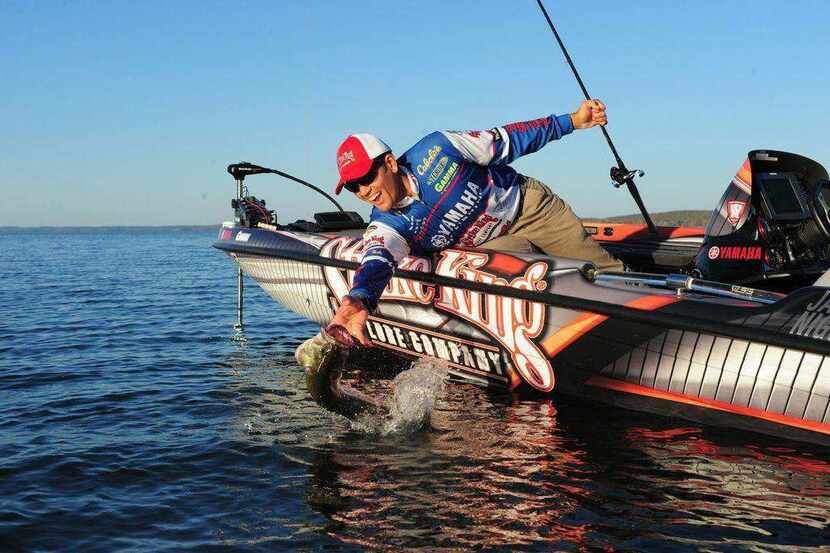 Bass pro and fishing guide James Niggemeyer reaches to land a good fish at Lake Fork....